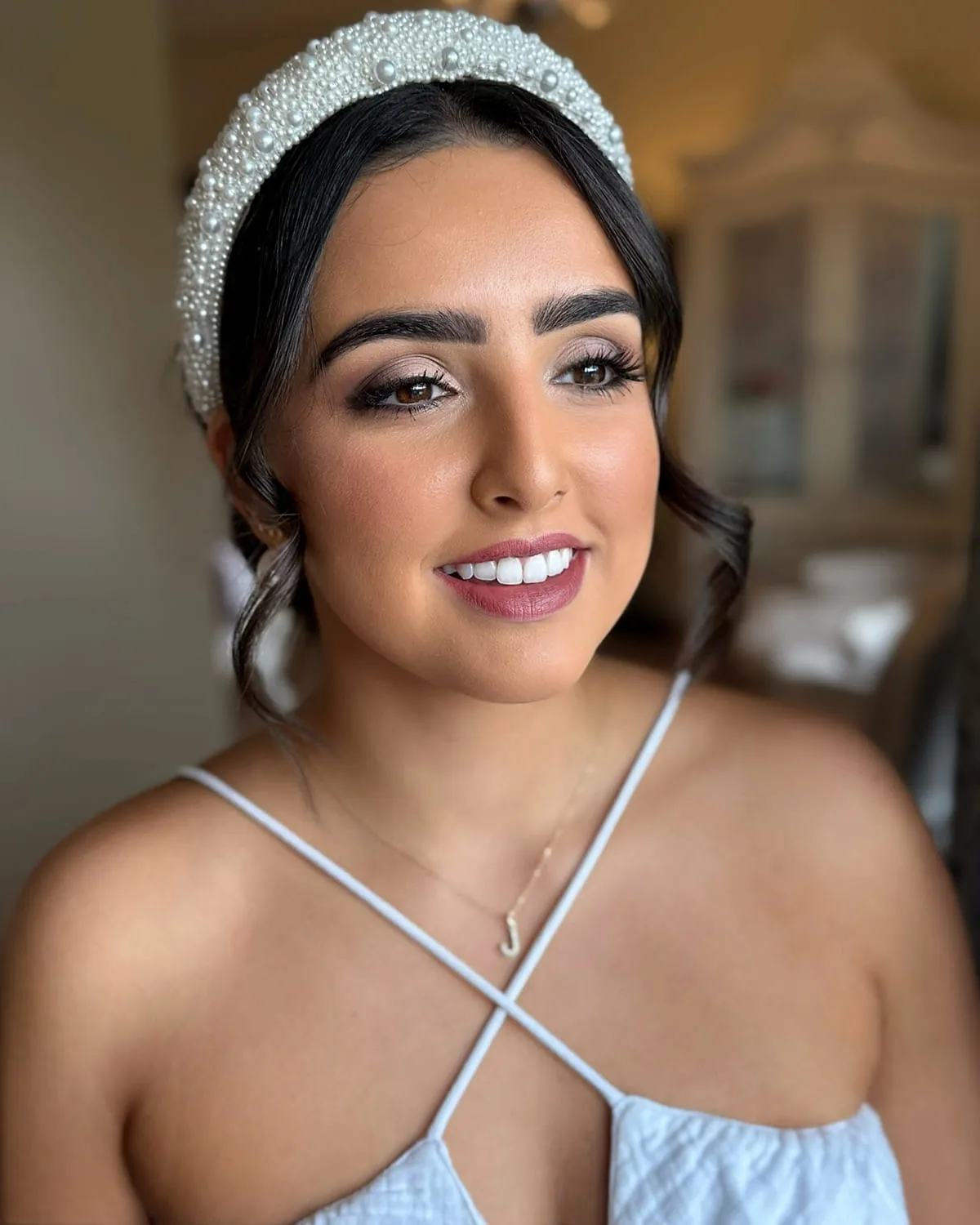 Bride wearing a pearl headband with luminous skin and a defined eye