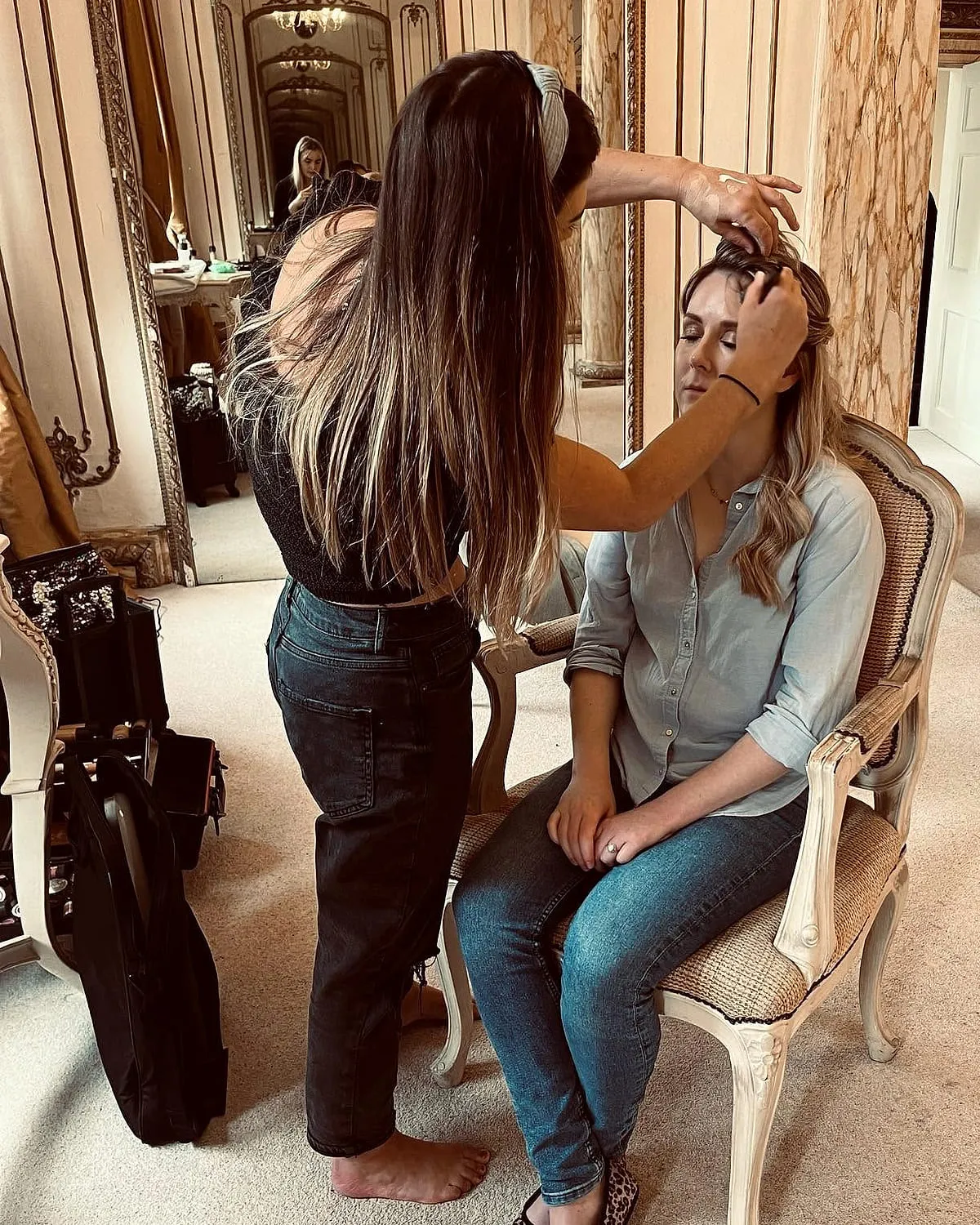 Hayley working on a bride's hair and makeup in a wedding venue suite