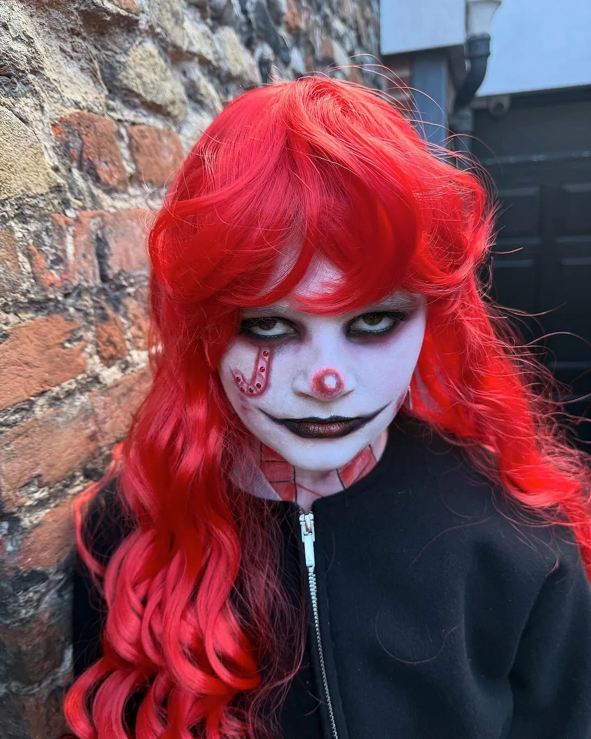 Halloween special-effects clown makeup photographed against brickwork