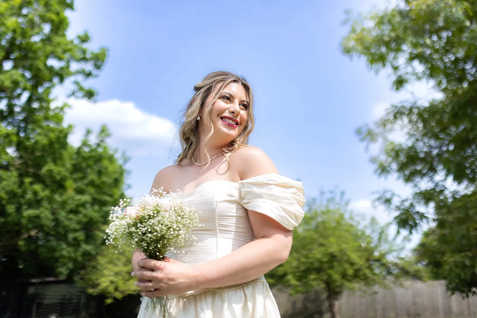 Bride outdoors holding her bouquet on the morning of the wedding