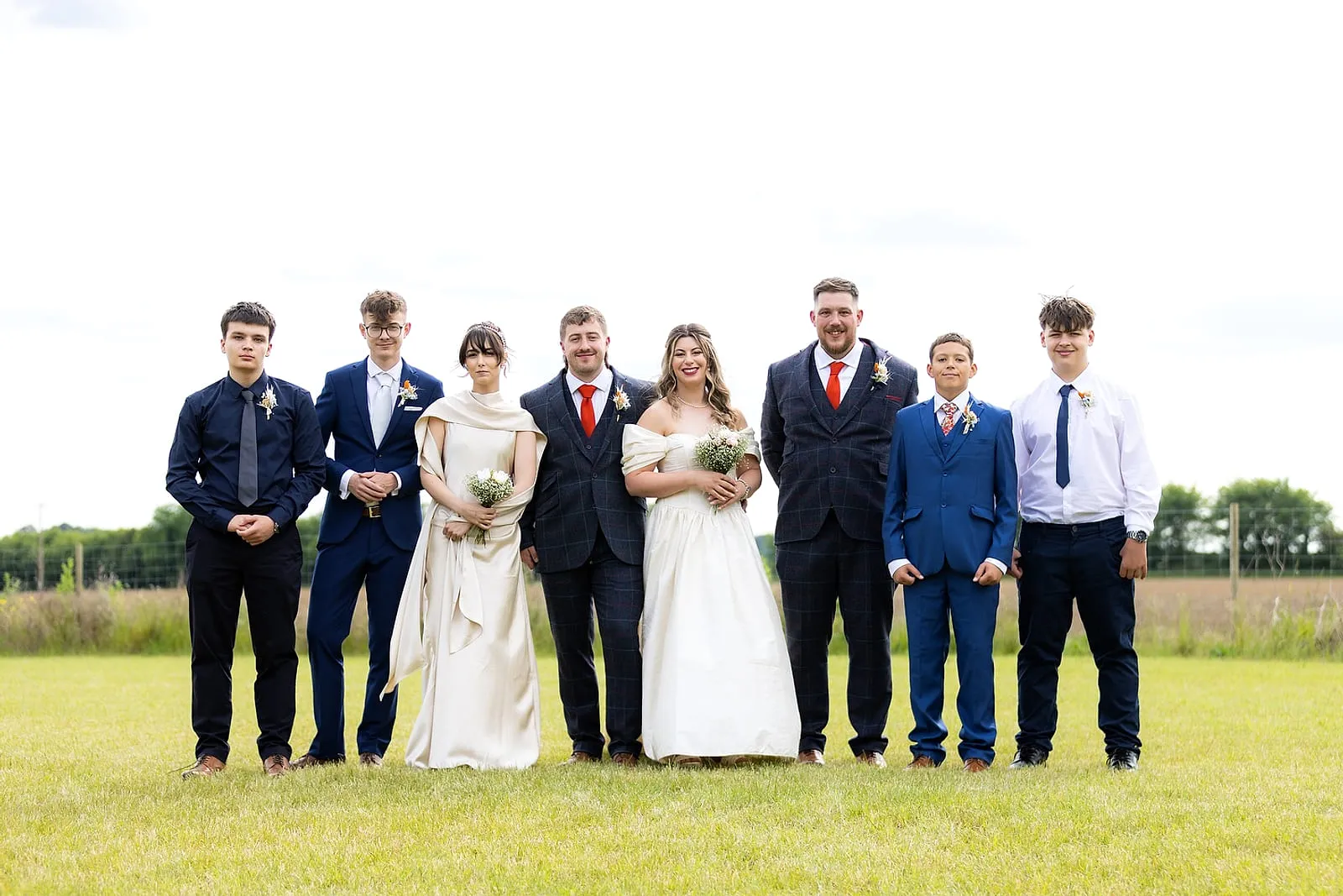 The full wedding party photographed together outdoors